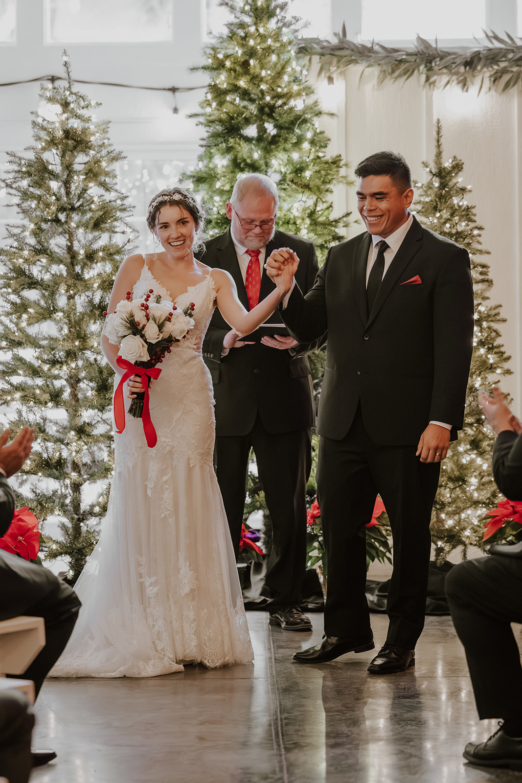 A newly married couple celebrating during an indoor winter wedding ceremony at Bella's Farmhouse