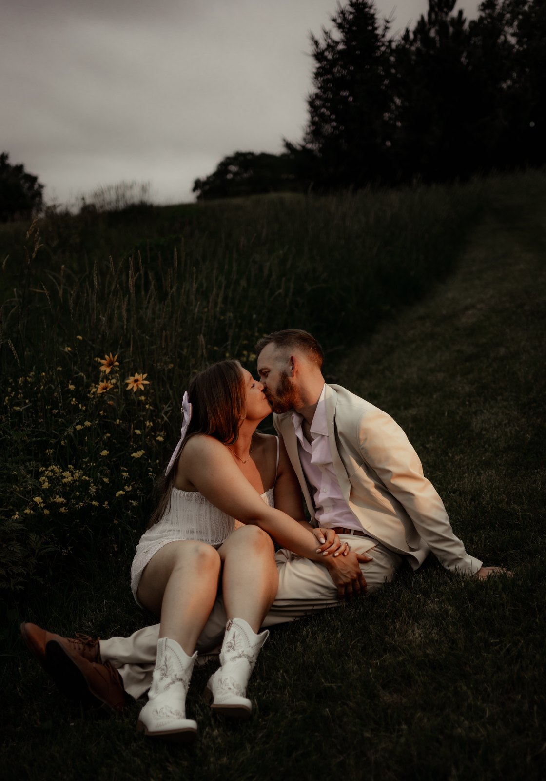 A newly married couple sharing a kiss in the meadow at Bella's Farmhouse